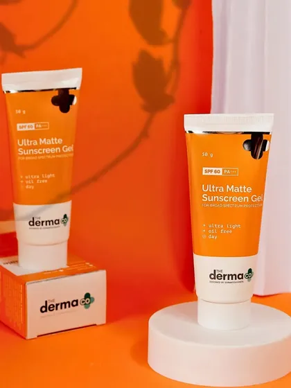 This shot for The Derma Co sunscreen includes the product's packaging, providing complete visual information for a potential customer on an e-commerce site.