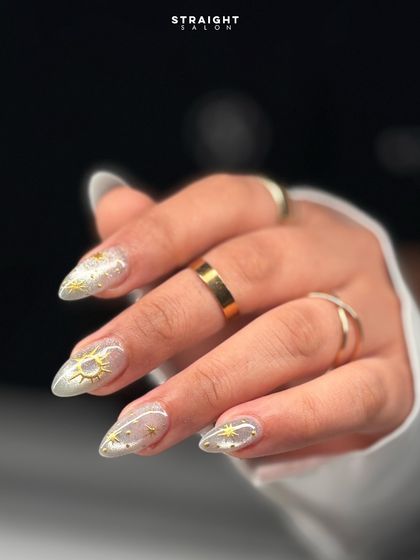 A celestial dream on your fingertips. This set features a sheer, shimmery base with hand-painted gold suns, moons, and stars for a magical look.