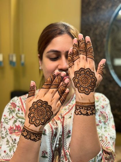 A happy client showing off her simple and beautiful mandala mehendi.