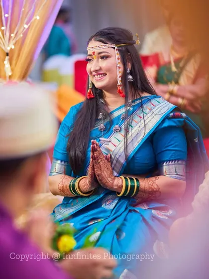 This is a beautiful candid portrait of the bride during a quiet moment in the ceremony. Her respectful gesture and warm smile show her grace and happiness.
