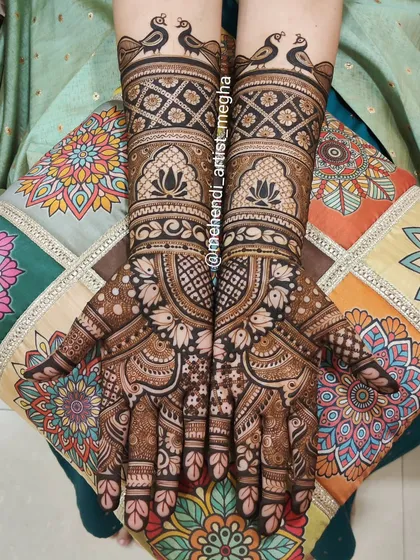 A classic full-hand mehendi design featuring graceful peacocks perched on the wrists and delicate lotus patterns, perfect for any grand celebration.