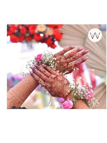A close-up of the henna stain, adorned with delicate floral jewelry.