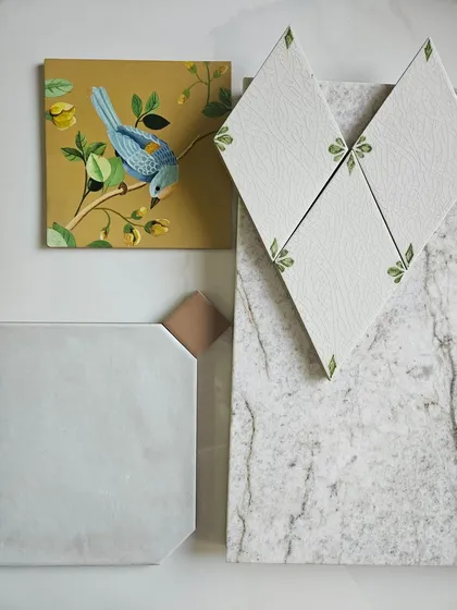 Here, I was playing with the idea of nature-inspired details. The hand-painted bird tile, the leaf-motif diamond tiles, and the textured stone sample create a story that is both whimsical and grounded in natural beauty.