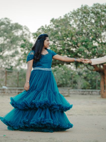 A classic pre-wedding pose in a park setting. The flowing blue gown adds a beautiful touch of elegance to this outdoor couple portrait.