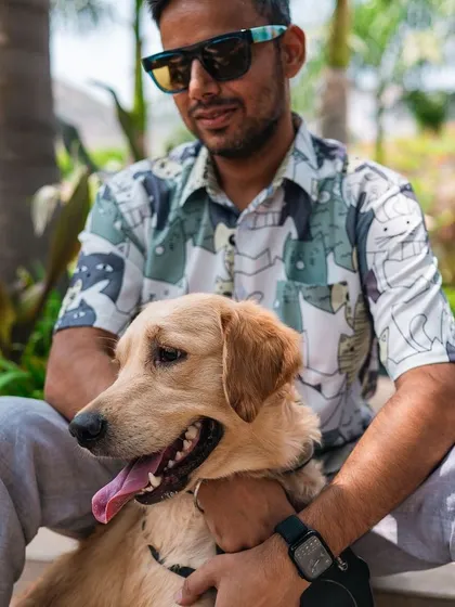 A man enjoys a quiet moment with his happy and relaxed dog. Our pet-friendly environment ensures that both you and your companion can unwind and feel completely at ease.