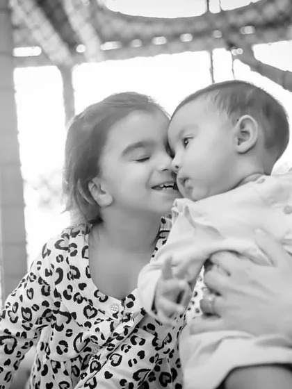 A sweet, tender moment between two siblings in the play area. This beautiful black and white photo captures the love and connection that family celebrations are all about.