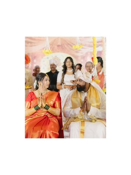 A moment of prayer during a Maharashtrian wedding ceremony. The couple's joined hands and reverent expressions capture the spiritual side of their union.