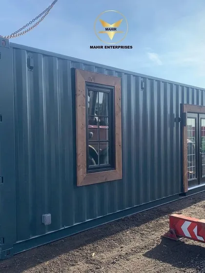 This beautiful unit has just arrived at the client's site, ready for final placement. The combination of dark corrugated steel, rustic wood-framed windows, and elegant French doors creates a distinctive and welcoming facade.