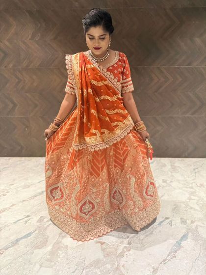 A top-down view showcasing the full flare and detailed embroidery on the skirt of this gorgeous orange lehenga.