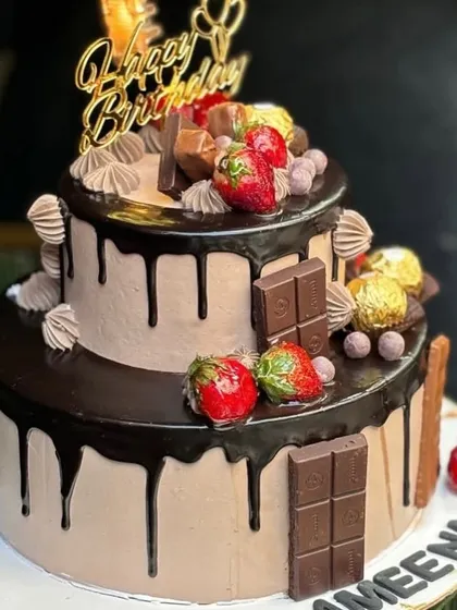 Another view of the decadent two-tier chocolate drip cake, showcasing the generous toppings and rich chocolate frosting. This cake is fully eggless and can be customized with your favorite treats.