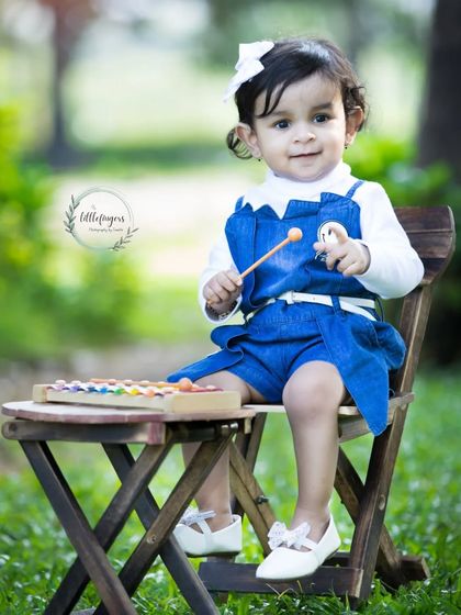 A moment to cherish forever. This sweet baby girl is playing a xylophone during her outdoor portrait session, her happy expression perfectly captured.