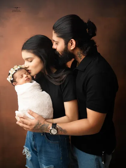 A mother's gentle kiss on her newborn's forehead. This classic pose is a simple yet powerful expression of love and protection.