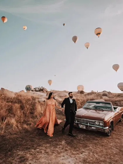 A candid moment of the couple walking hand-in-hand. The gown flows beautifully as they move, adding a touch of elegance to this adventurous shot in Turkey.