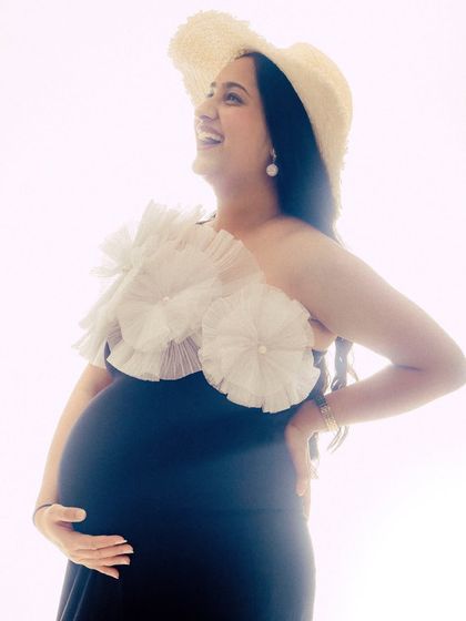 A joyful, high-key portrait of a mama-to-be in our Veneccia gown. The bright lighting creates a happy and angelic feel.
