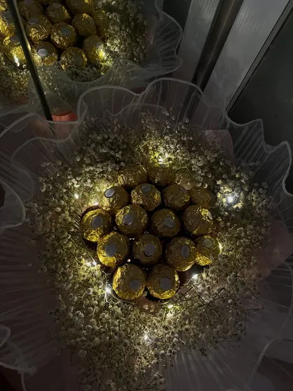 Imagine their face when they see this. I arrange luxurious Ferrero Rocher chocolates in a cloud of baby's breath and weave in delicate fairy lights to create a truly magical and edible gift, perfect for a memorable first date or anniversary.