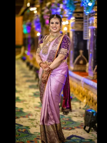 A full-length view of the lavender Kanjeevaram saree paired with the custom-designed, heavily embroidered purple blouse. The contrast creates a striking silhouette perfect for a grand celebration.