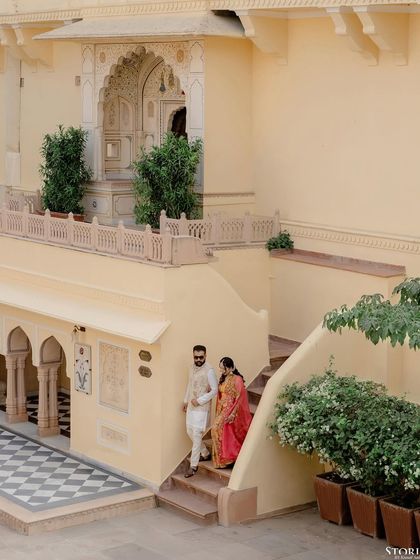 An elevated shot of the couple descending a staircase at the palace, capturing the grandeur of the location.