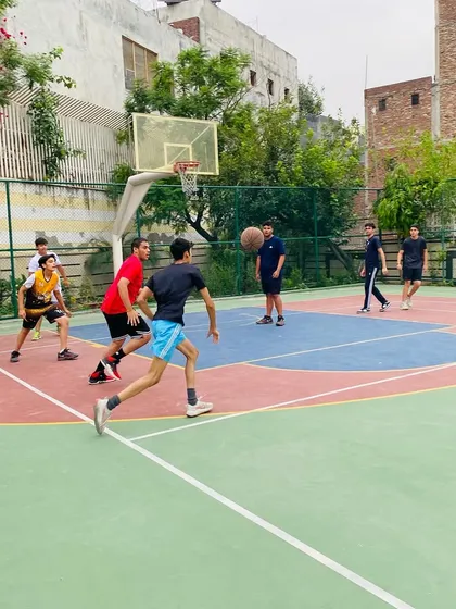 A player dribbles with his head up, scanning the court for open teammates. This is a fundamental habit for good point guard play.