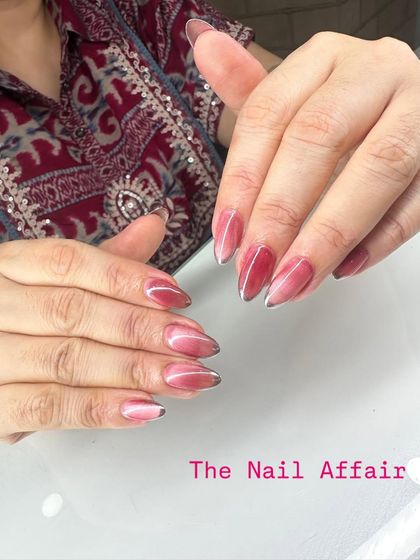 A unique take on the ombré trend, this design features a reddish-pink cat eye polish that fades to a sheer tip, creating a deep, dimensional effect.