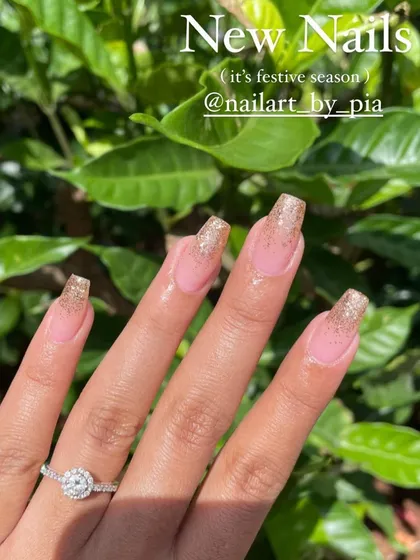 Another happy client showing off her festive gold glitter nails.