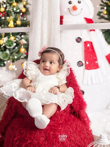 What more could one ask for? This happy baby girl, sitting on a big red teddy bear, is the perfect picture of Christmas joy.