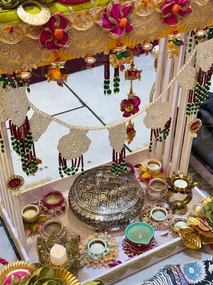 A closer look at a traditional Diwali hamper. This setup features a beautiful silver box, decorated 'diyas', and a stunning 'toran' with pearl and bead work.