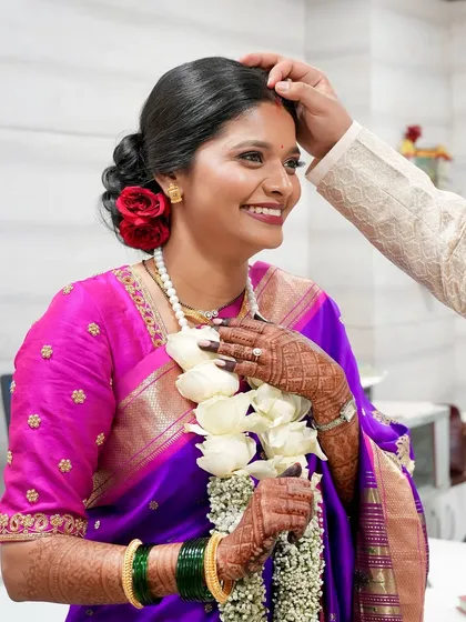 A moment of blessing. The bride's happy and emotional expression is the centerpiece, with her makeup providing a flawless canvas.