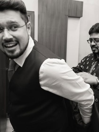 A fun, behind-the-scenes moment of the groom getting ready with his friend.