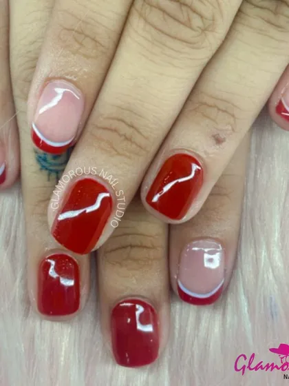 A modern and minimalist design with a mix of solid red nails and sheer accent nails featuring a simple, elegant white swirl.