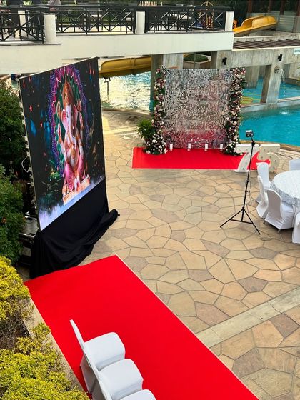A poolside 75th birthday celebration featuring a large LED screen for videos and a stunning silver sequin photo wall.