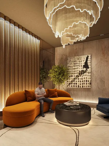The lounge at Palais Royale was crafted to be a lifestyle statement. A dramatic sculptural chandelier hangs above a curved orange sofa and a plush blue armchair, creating a sophisticated space that balances leisure and grandeur.