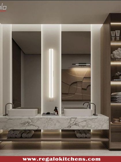 A double vanity with a floating marble counter and open lower shelf for towel storage. The design includes a full-height cabinet with illuminated shelving for toiletries.