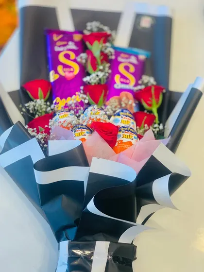 A full view of the popular red rose and chocolate bouquet. This design uses black Korean-style wrapping with a white border to make the red roses and purple Dairy Milk chocolates stand out.