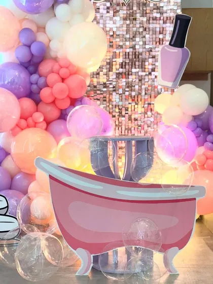 A tight shot on the spa party props, giving a clear view of the bathtub cutout and the clear "bubble" balloons at its base. This detail shot showcases the creative elements that make our themes unique.