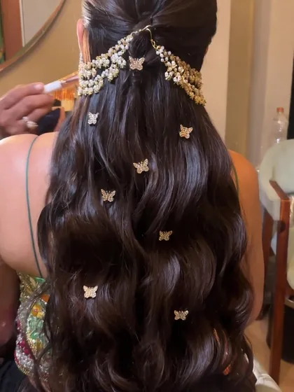A detailed shot of the butterfly-adorned hairstyle. The combination of the traditional hair jewelry and the playful butterfly clips is a unique fusion.