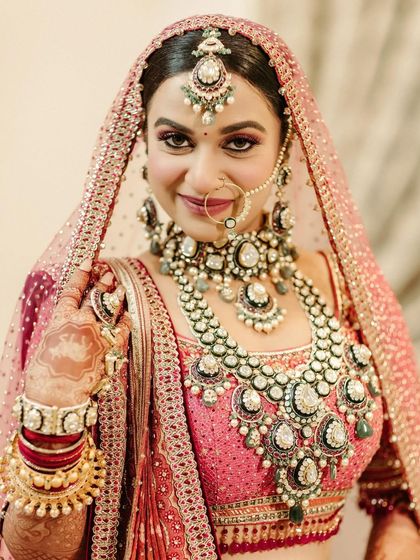 A close-up of the bride, focusing on her stunning, multi-layered polki necklace and radiant smile, capturing the essence of a royal bride.