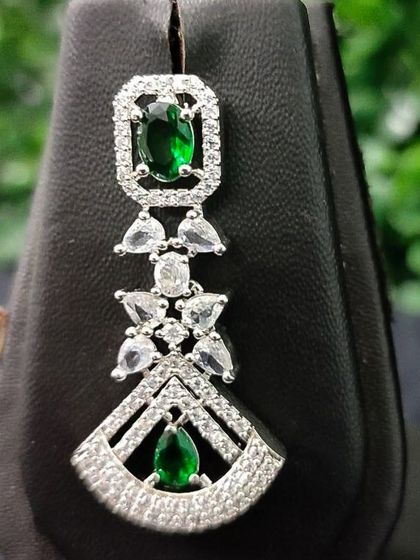 A detailed shot of the earring from the emerald-green set, showing the combination of different stone shapes.