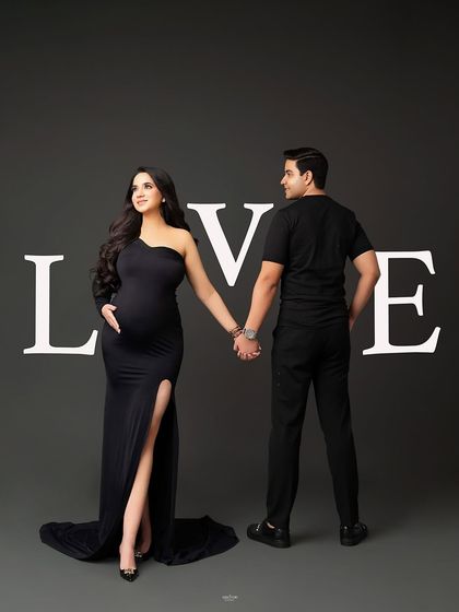 A powerful "LOVE" portrait with the couple holding hands, looking towards their future together. The one-shoulder black gown is so chic.