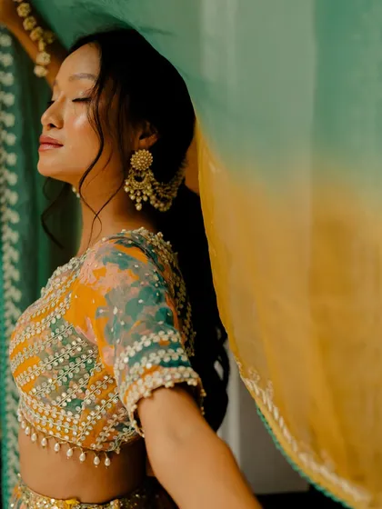 A close-up of the embellished blouse of the tie-dye lehenga, showcasing the intricate beadwork and sequins.