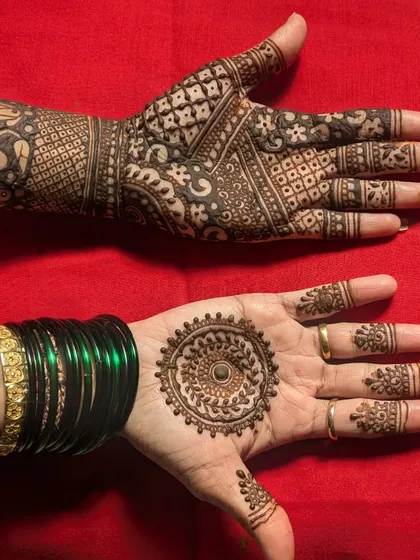 A great example of varied designs for guests. One hand features a traditional mandala, while the other has a more modern, asymmetrical pattern.