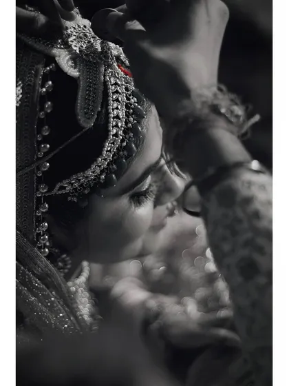 Wedding photography for me is about capturing the small, unseen moments. This black and white shot focuses on the gentle act of the groom adjusting the bride's traditional headpiece, a quiet, intimate gesture filled with emotion amidst the ceremony.
