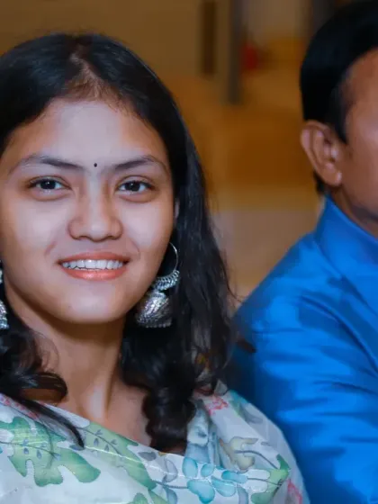 A candid portrait of a young guest with a warm smile, enjoying the family celebration.