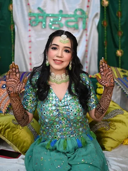 My happy mehendi bride Hrishika. Her mirror-work outfit in shades of green and blue is so festive and fun.