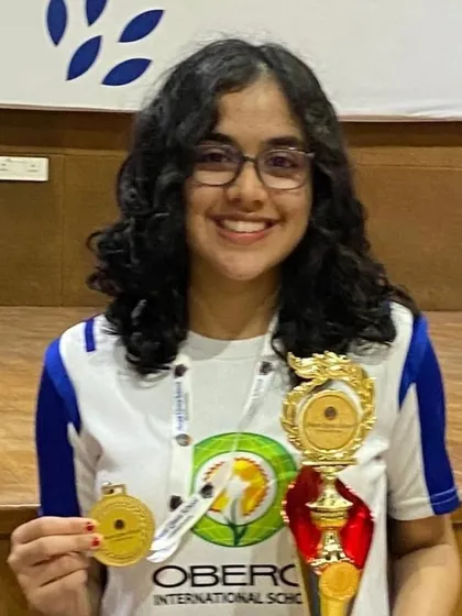 A close-up of Ariaana Sood, winner of the U-17 Girls category at the IB Interschool Tournament, showcasing her gold medal and trophy.