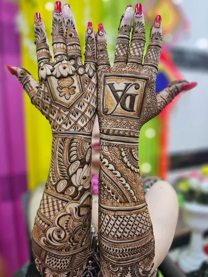 A stunning full-coverage bridal design on both hands. This style uses dense, intricate patterns and a bold initial monogram to create a very rich and traditional look.
