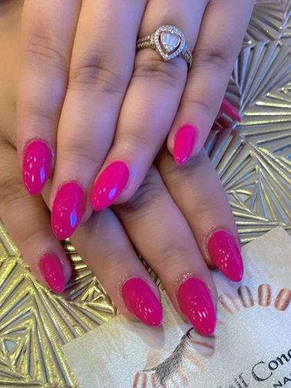 A vibrant set of almond-shaped nails in a deep, glossy magenta. This bold color is both fun and sophisticated.