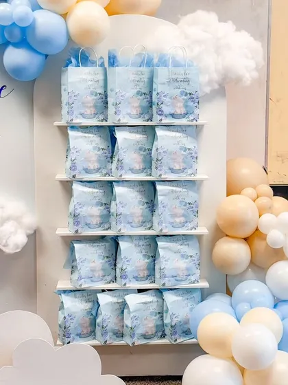 Custom-designed favor bags displayed on a dedicated shelf, perfectly integrated into the "Over the Moon" themed decor.