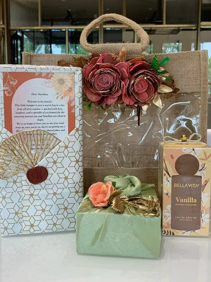 "Welcome to the family!" This warm and inviting hamper is the perfect way for cousins to welcome a groom-to-be. It features a jute bag, a personalized letter, perfume, and other thoughtful gifts.