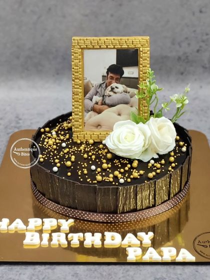 A timeless moment captured on a cake for a father's birthday. This design features an edible photo in a golden frame, elegantly placed on a rich chocolate cake.