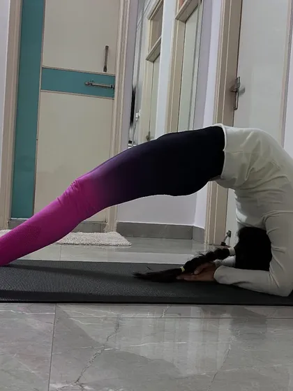 A student holding a challenging backbend on her forearms, demonstrating significant progress in spinal flexibility and strength.